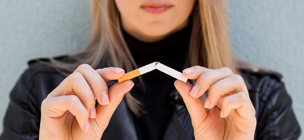 Person breaking a cigarette to quit smoking