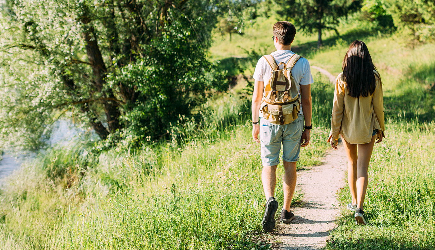 Two people walking on a path in a natural setting