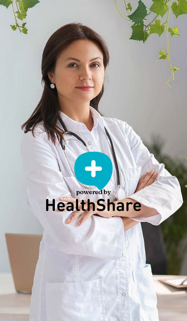 Woman in a white coat with a stethoscope, standing in a professional setting with 'HealthShare' branding.