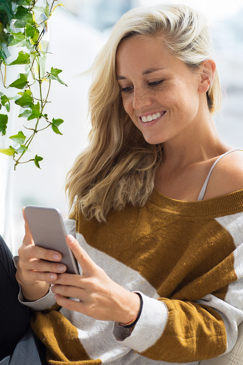 A smiling blonde woman applying for a vape prescription online.