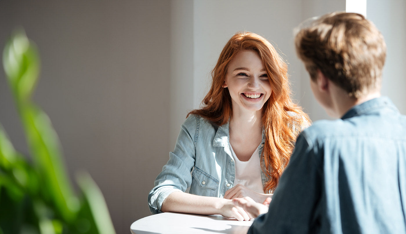 Two people sitting at a table, engaged in a conversation about quitting smoking in a clinic.