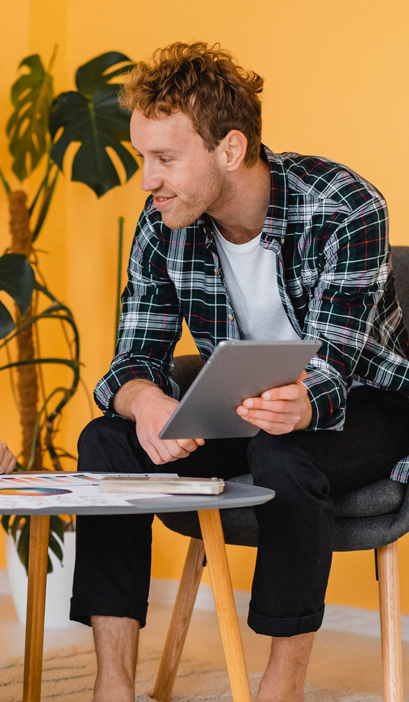 Man sitting on a chair holding a tablet looking up quit smoking treatments